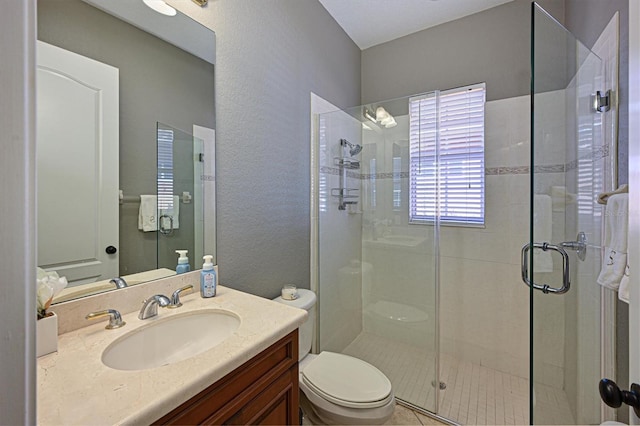 bathroom featuring toilet, an enclosed shower, and vanity