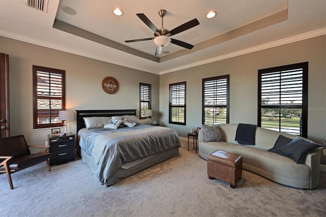 bedroom featuring a raised ceiling, ceiling fan, carpet, and ornamental molding