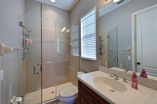 bathroom with toilet, an enclosed shower, and vanity