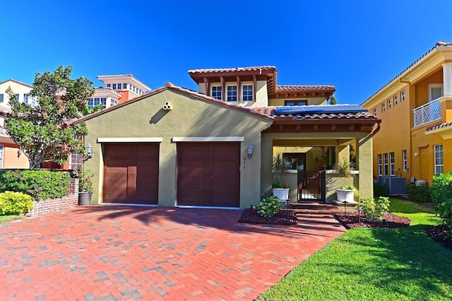 mediterranean / spanish-style home with a garage and central air condition unit