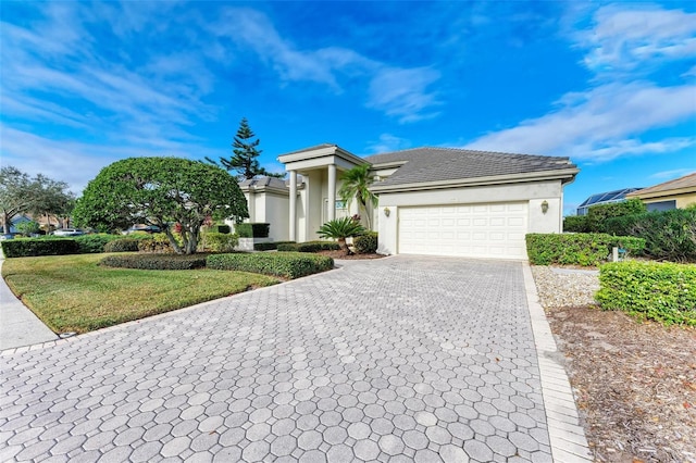 view of front of property featuring a garage and a front lawn