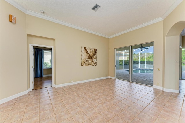 spare room with light tile patterned floors, crown molding, and a textured ceiling