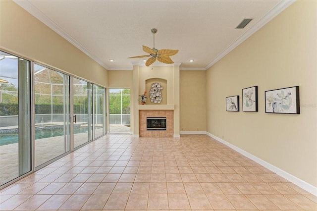 unfurnished living room featuring ceiling fan, ornamental molding, a tile fireplace, and light tile patterned floors