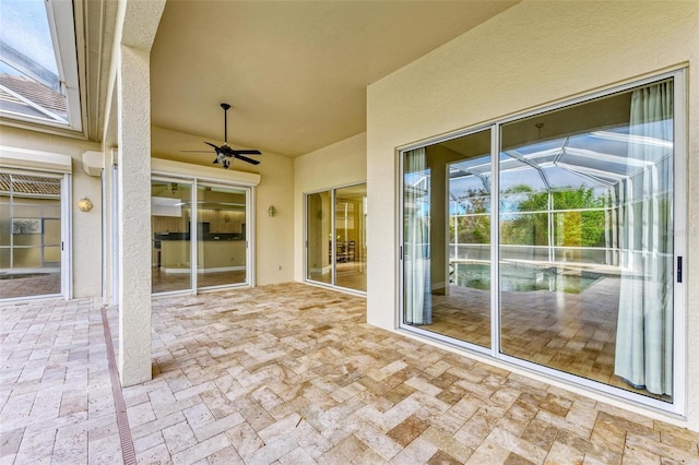 view of patio / terrace featuring ceiling fan and a lanai