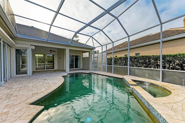 view of swimming pool with an in ground hot tub, a patio, ceiling fan, and glass enclosure