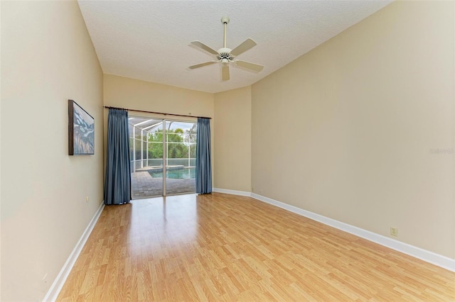 empty room with ceiling fan, a textured ceiling, and light wood-type flooring