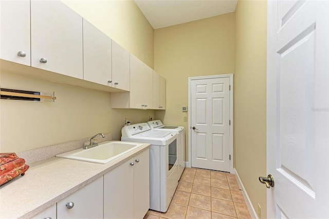 laundry room with light tile patterned flooring, sink, cabinets, a high ceiling, and washer and clothes dryer