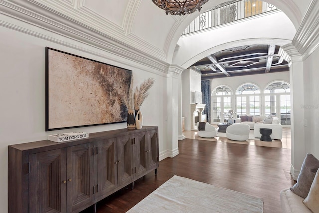 entrance foyer with dark wood-type flooring, crown molding, decorative columns, beam ceiling, and coffered ceiling