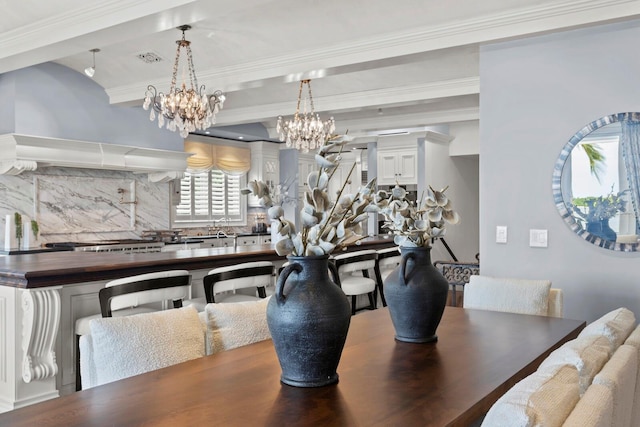 dining space with ornamental molding and a notable chandelier