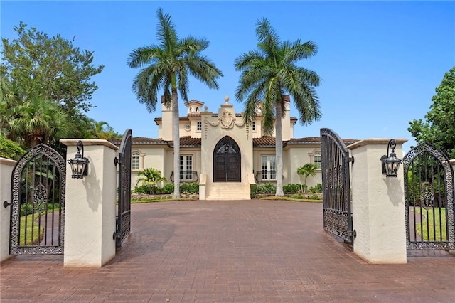 exterior space with stucco siding and a gate