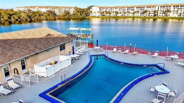 view of swimming pool featuring a patio and a water view