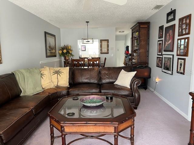 living room featuring light colored carpet and a textured ceiling