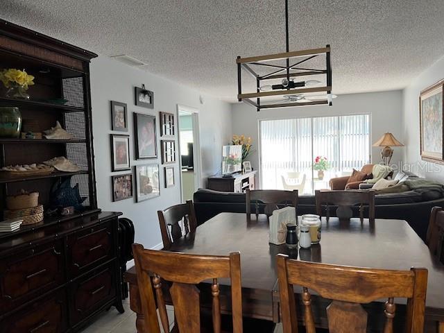 dining area featuring a chandelier and a textured ceiling