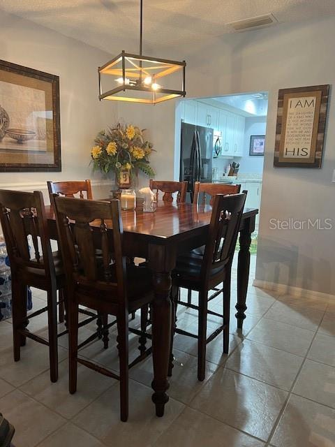 tiled dining area featuring an inviting chandelier