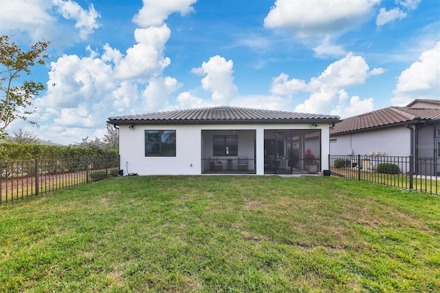 back of house featuring a sunroom and a lawn