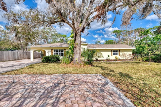 ranch-style home with a front yard and a carport