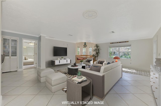 living room featuring light tile patterned flooring, ceiling fan, crown molding, and a textured ceiling