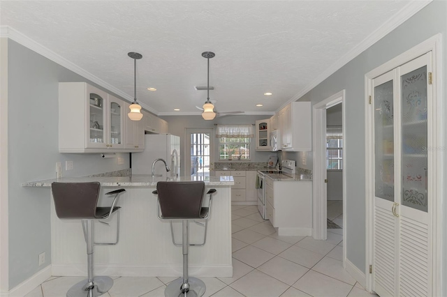 kitchen with crown molding, white appliances, a kitchen breakfast bar, white cabinets, and kitchen peninsula