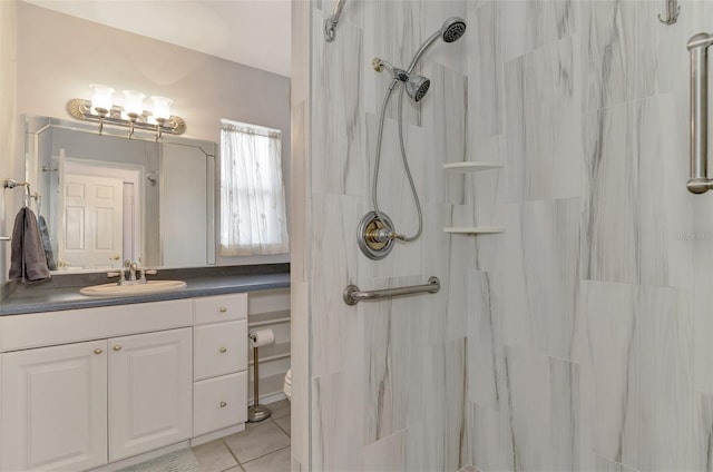 bathroom with vanity, toilet, tile patterned flooring, and a tile shower