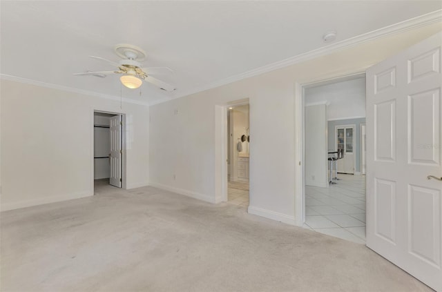 carpeted empty room with ceiling fan and ornamental molding