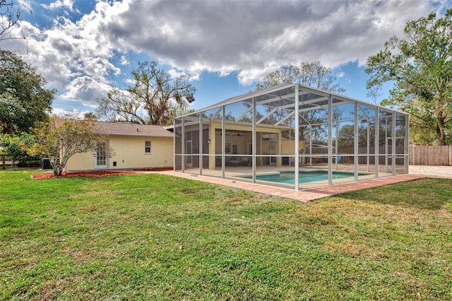 rear view of house featuring a fenced in pool, a patio area, ceiling fan, and a lawn