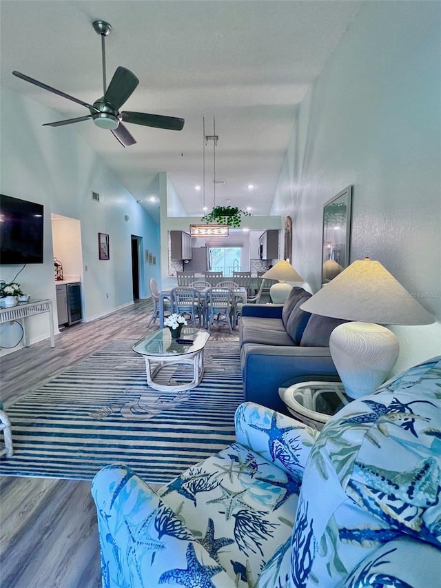 living room featuring hardwood / wood-style floors, ceiling fan, and high vaulted ceiling