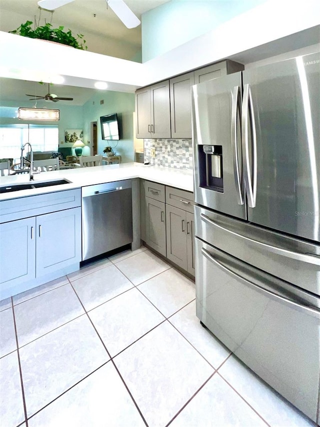kitchen featuring ceiling fan, decorative backsplash, sink, and appliances with stainless steel finishes