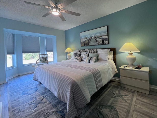 bedroom featuring hardwood / wood-style floors, a textured ceiling, and ceiling fan
