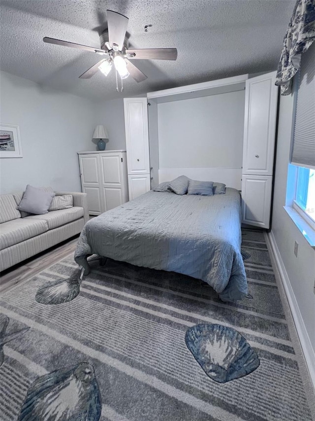 bedroom with ceiling fan and a textured ceiling