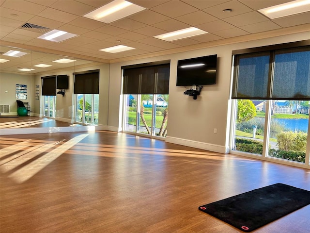 workout area featuring hardwood / wood-style floors and a paneled ceiling
