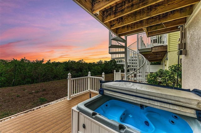 deck at dusk with a hot tub