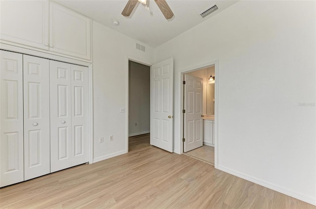 unfurnished bedroom featuring ensuite bathroom, a closet, ceiling fan, and light wood-type flooring