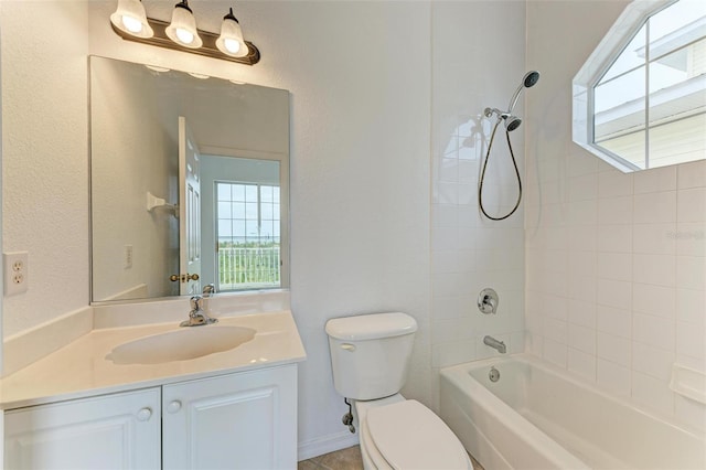 full bathroom featuring vanity, tiled shower / bath, and toilet