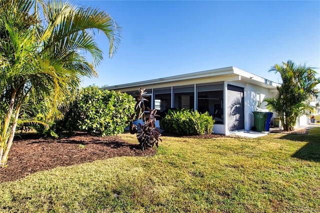 rear view of property with a sunroom and a yard