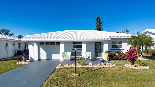 view of front of home with central AC, a front lawn, and a garage