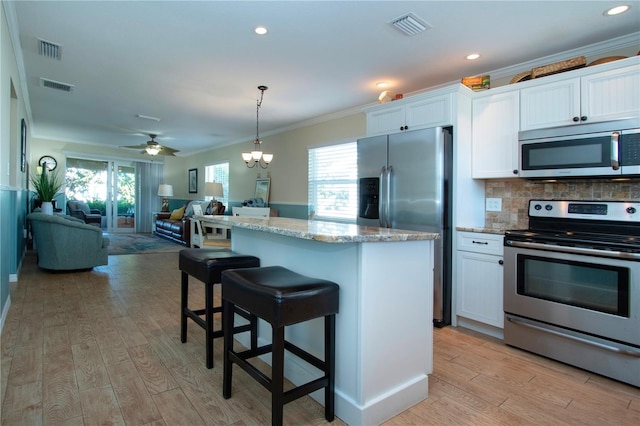 kitchen with ceiling fan with notable chandelier, stainless steel appliances, white cabinetry, and tasteful backsplash