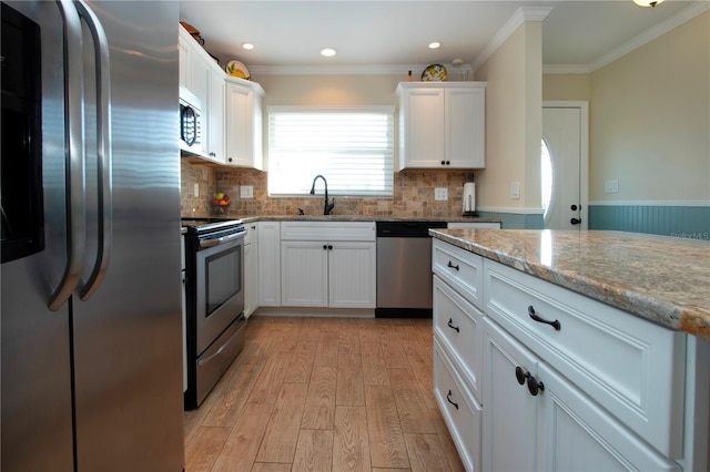 kitchen featuring white cabinets, sink, crown molding, light stone counters, and stainless steel appliances