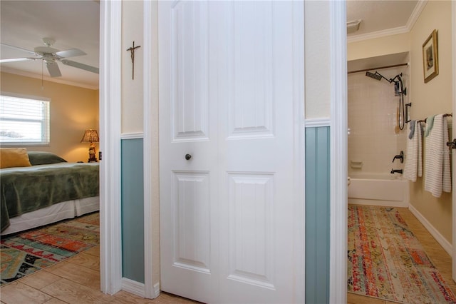 bathroom with wood-type flooring, tiled shower / bath combo, ceiling fan, and ornamental molding