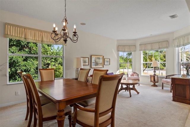 carpeted dining area featuring a chandelier