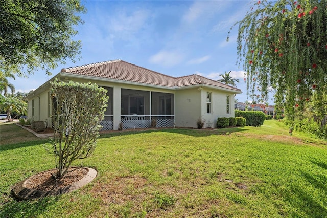 back of property featuring a yard and a sunroom