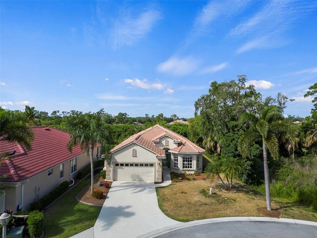 mediterranean / spanish home featuring a garage and a front yard