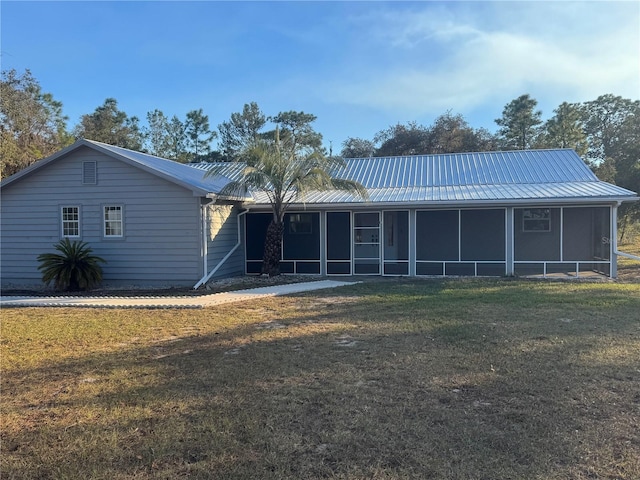 view of front of property with a front yard and a sunroom