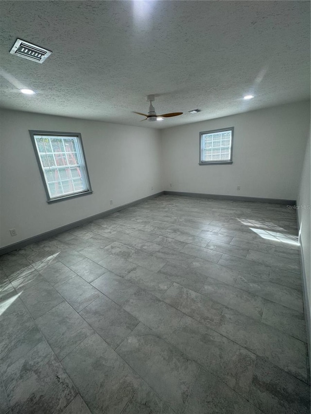 empty room featuring ceiling fan and a textured ceiling