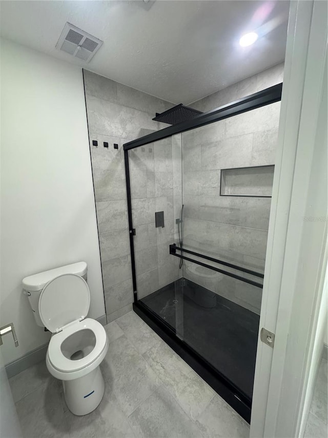 bathroom featuring toilet and walk in shower