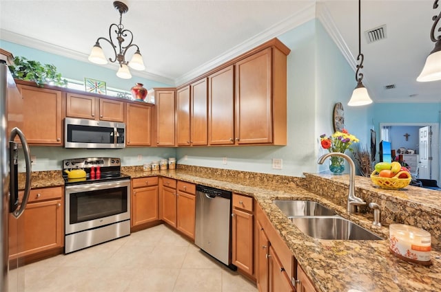 kitchen with ornamental molding, stainless steel appliances, sink, pendant lighting, and a notable chandelier