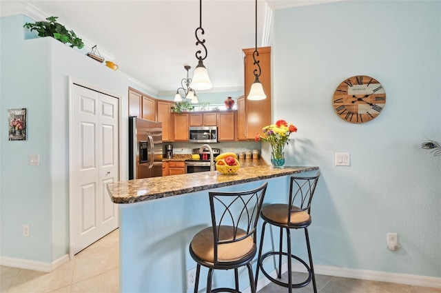 kitchen featuring hanging light fixtures, stainless steel appliances, kitchen peninsula, crown molding, and a breakfast bar area