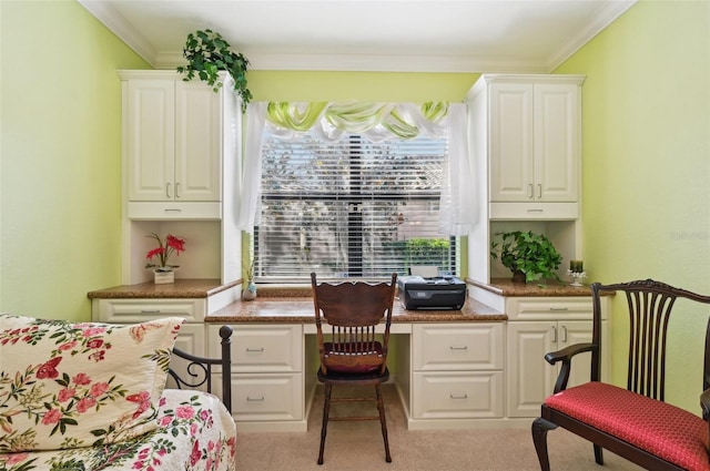 office area with crown molding, built in desk, and light colored carpet