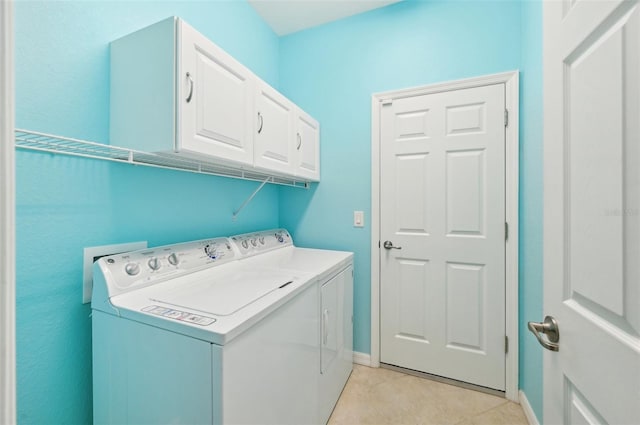 laundry room featuring separate washer and dryer, light tile patterned floors, and cabinets