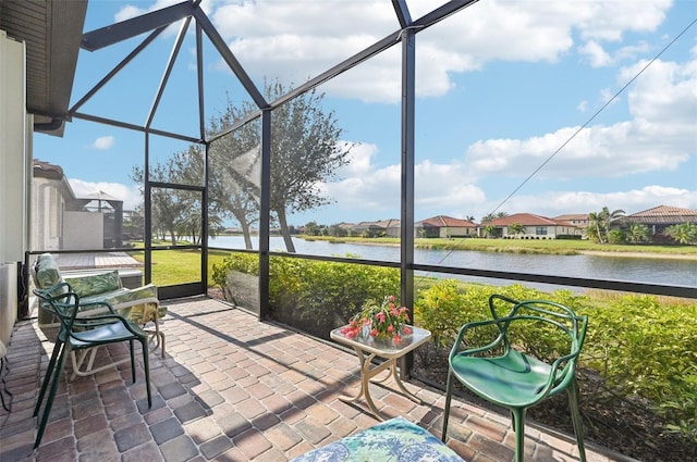 sunroom featuring a water view