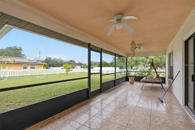 unfurnished sunroom with ceiling fan